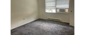 an empty room with a window and a radiator