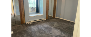 an empty room with a large mirror and a window