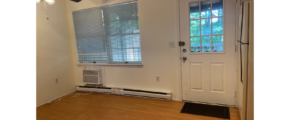 an empty room with a fan and a door