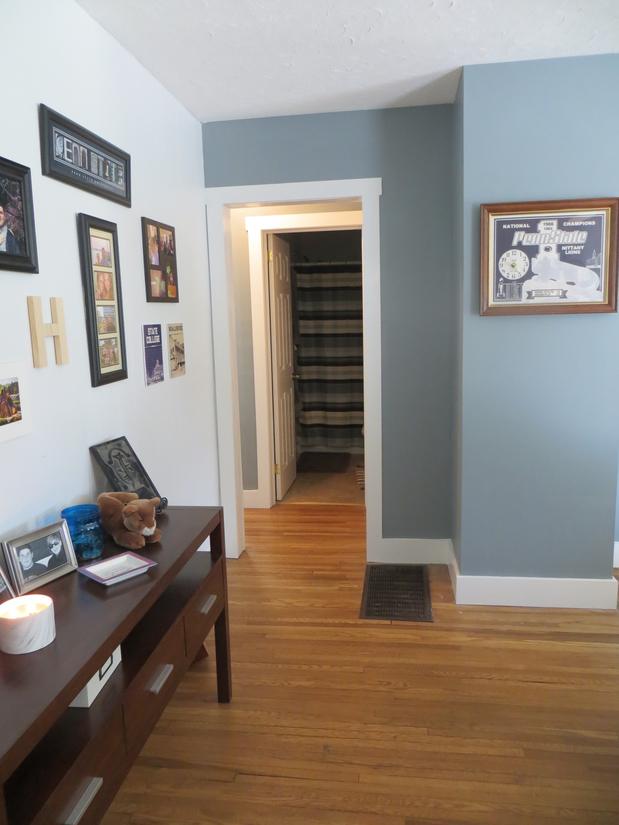 Hallway with framed art and wooden floor