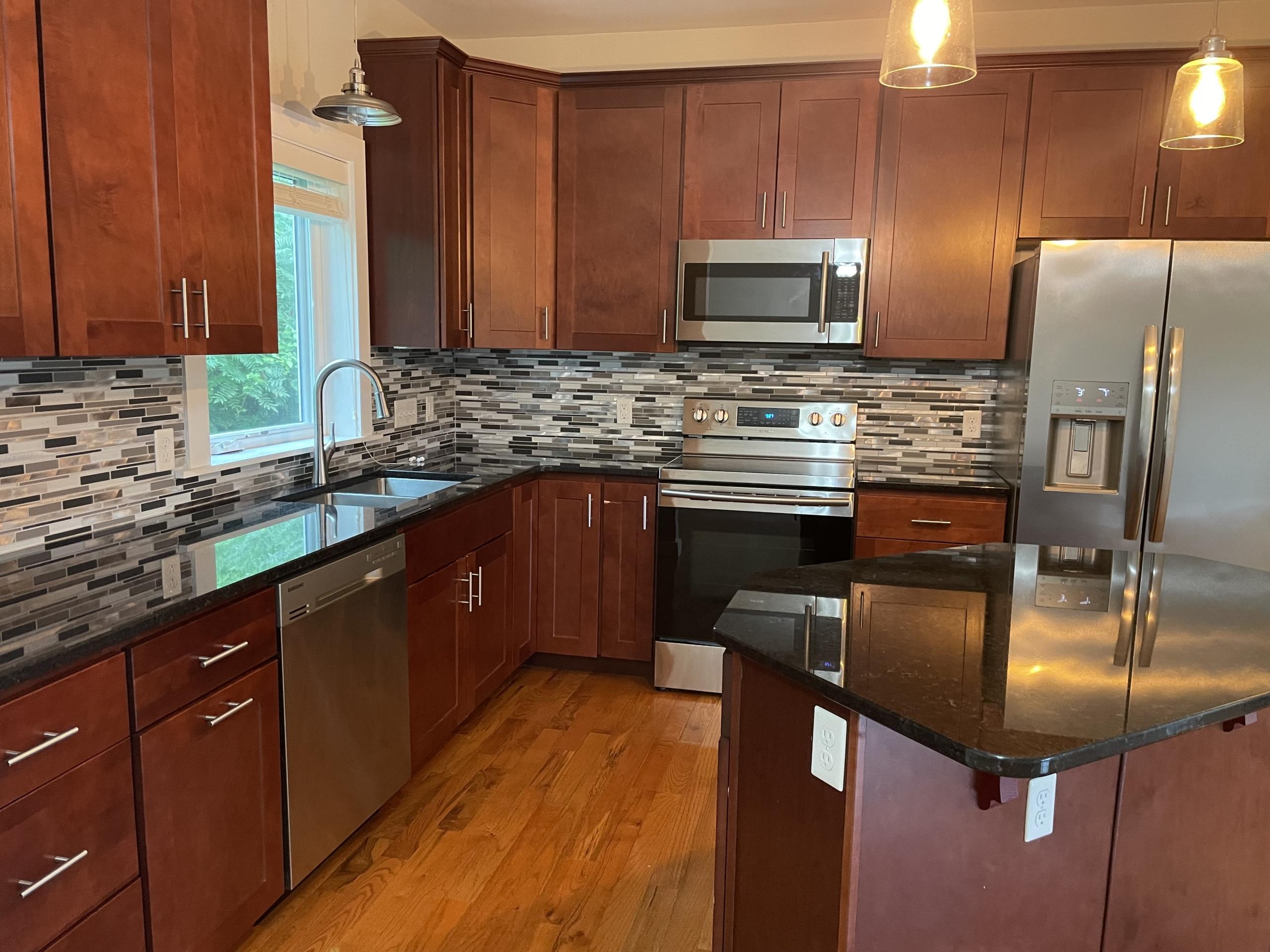Modern cherry wood kitchen with stainless steel appliances.