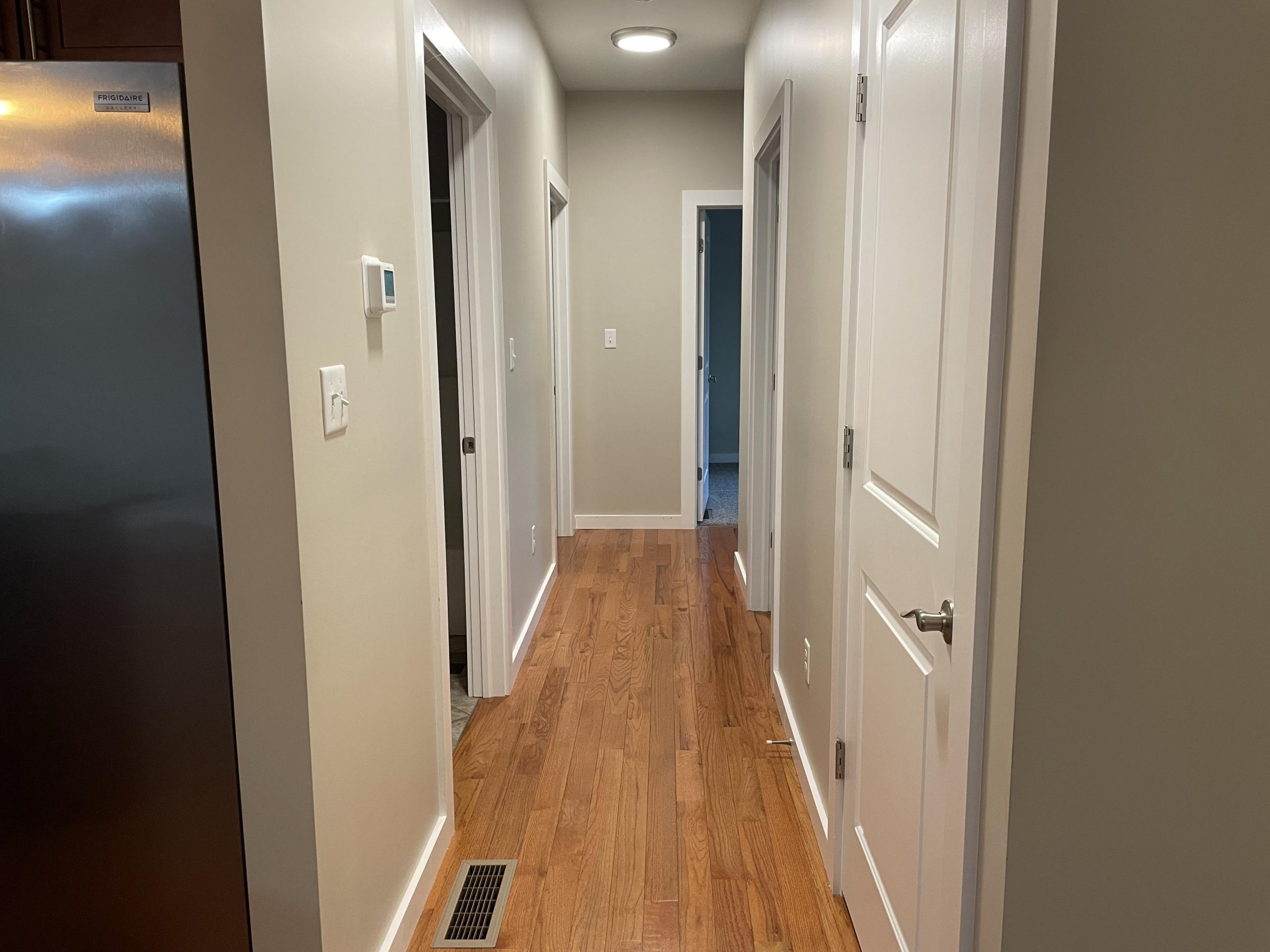 Hallway with hardwood floors and white doors