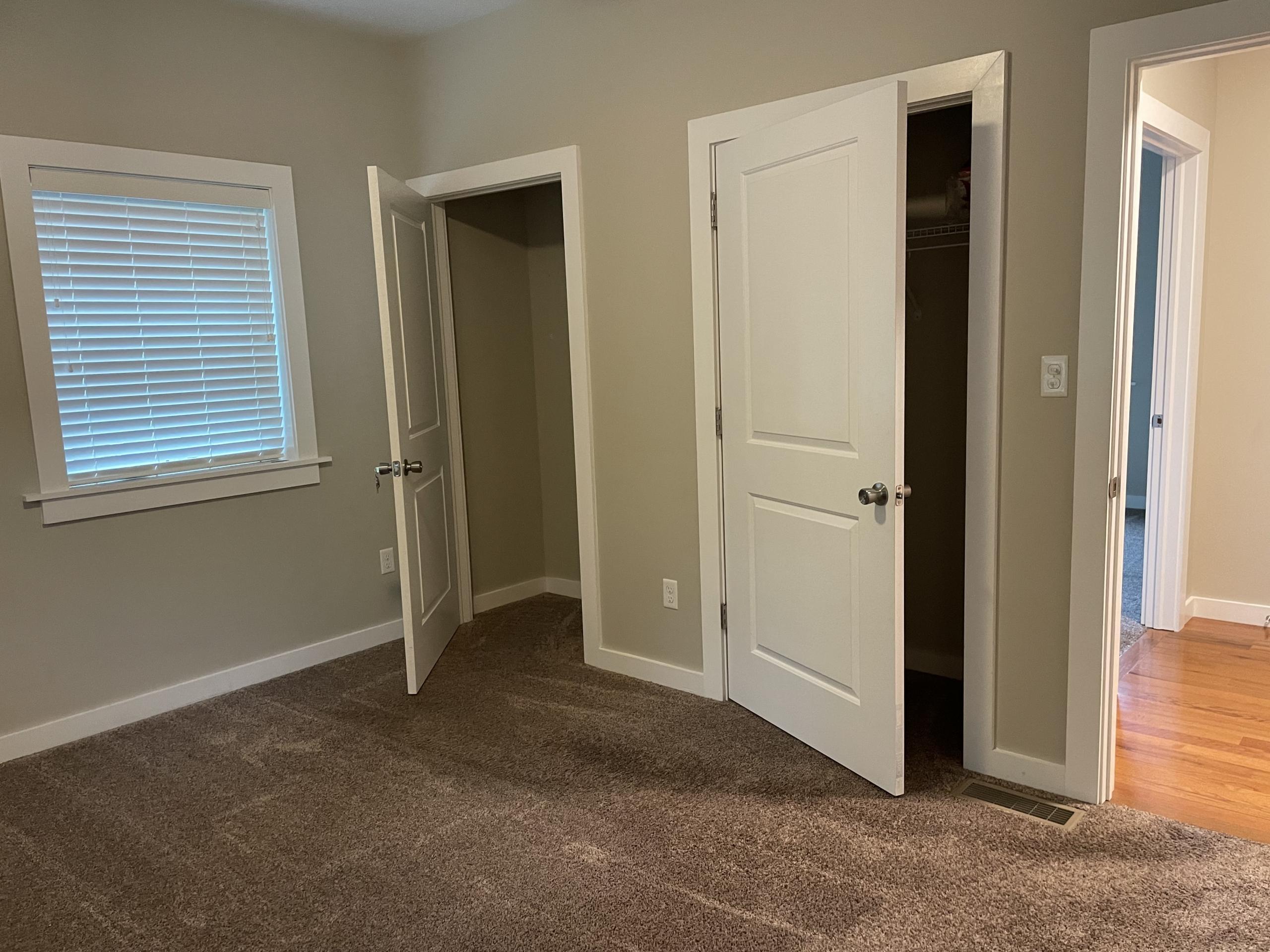 Bedroom with two closets and window