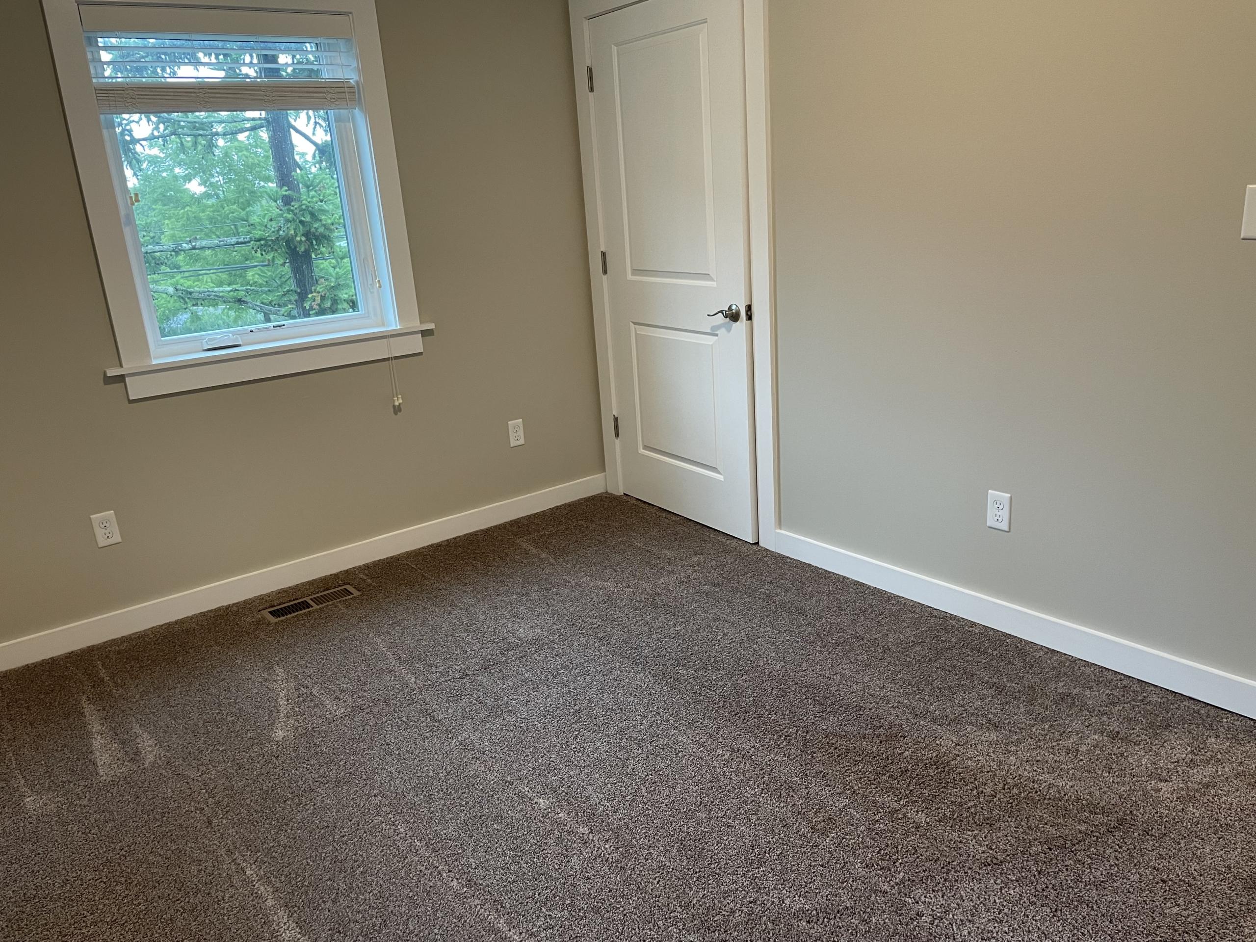 Empty bedroom with carpet and window