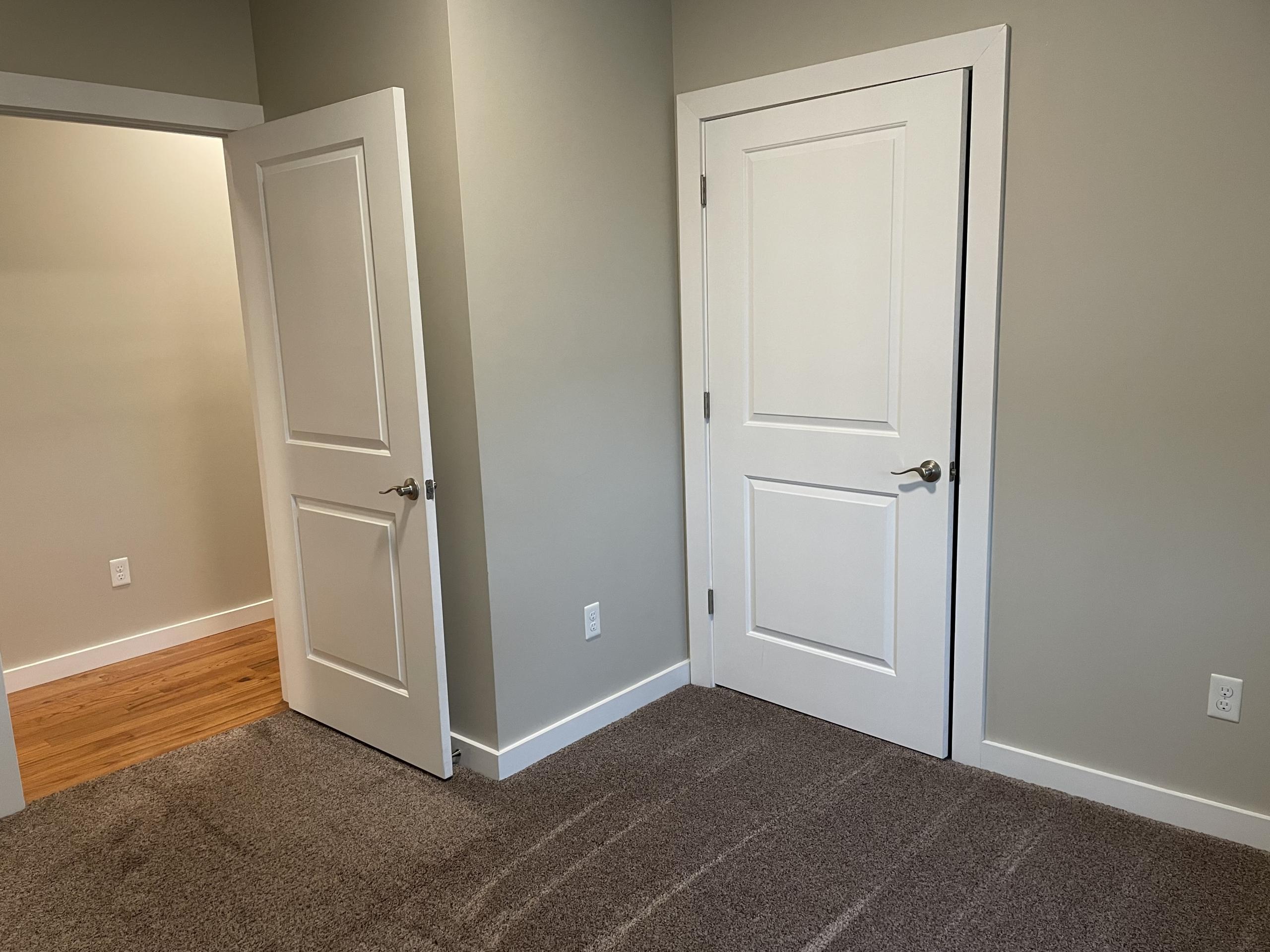 Two doors in a neutral-colored room.