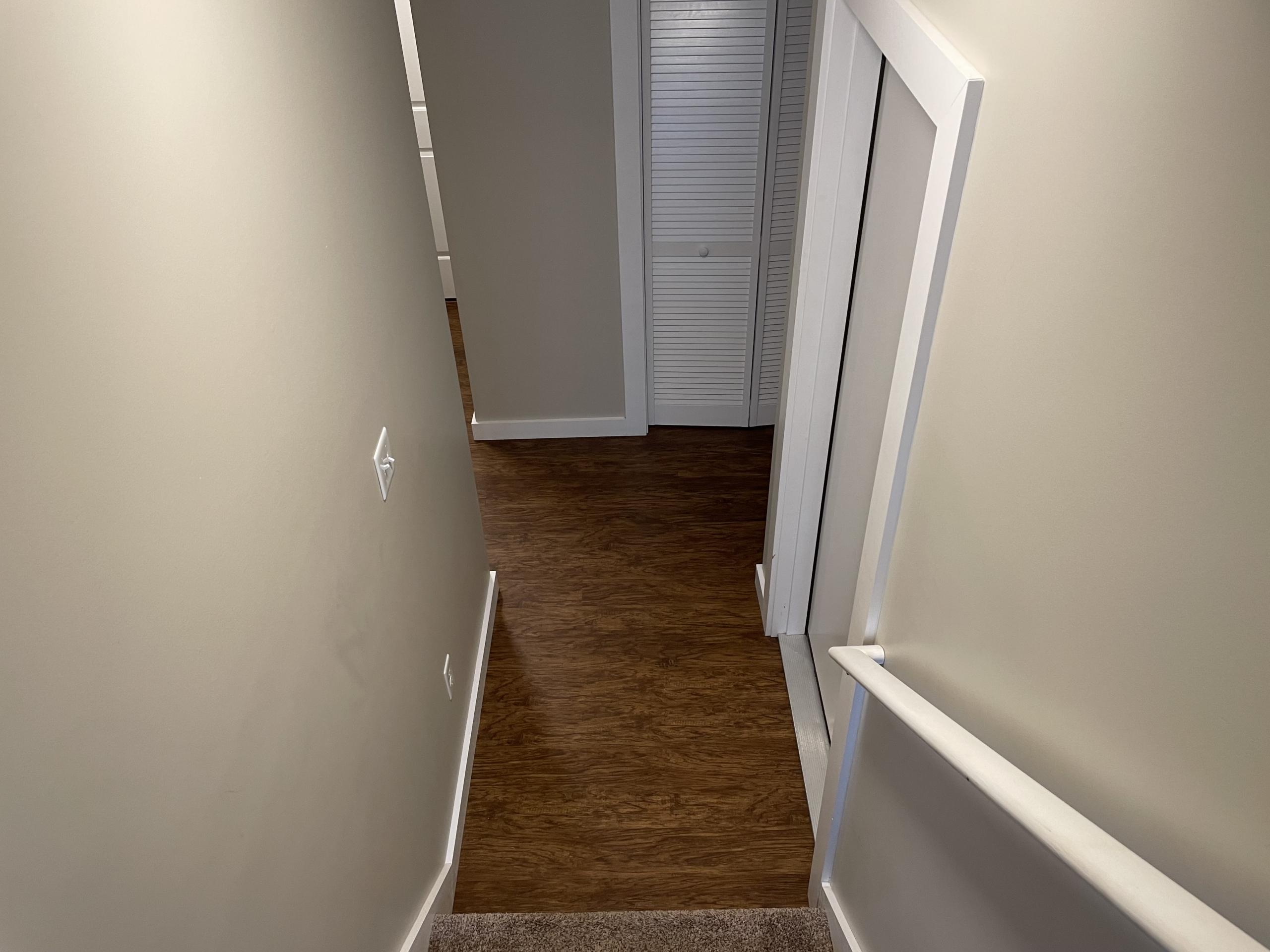 Hallway with wood floor and white door