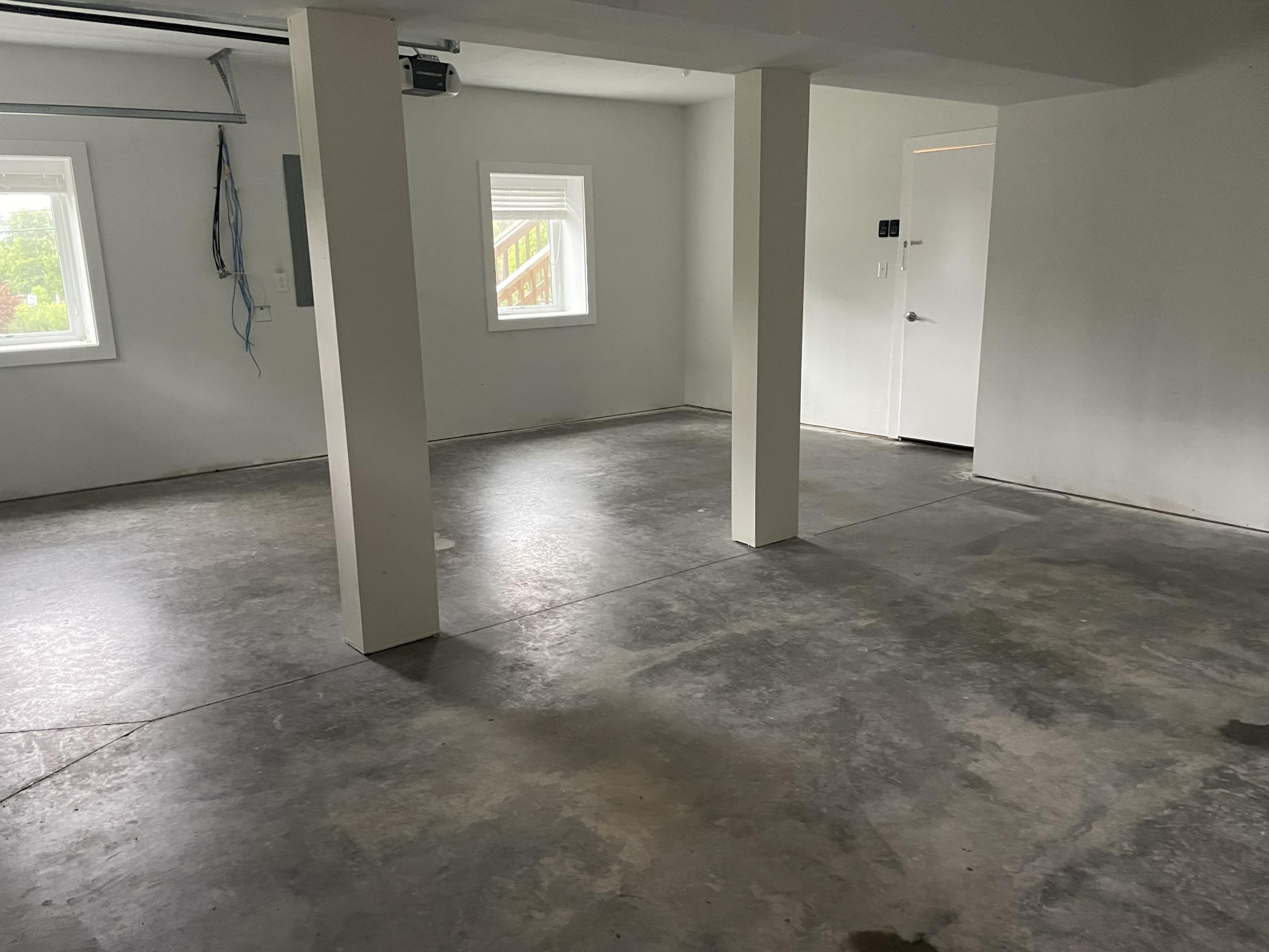 Empty garage interior with concrete floor and white walls