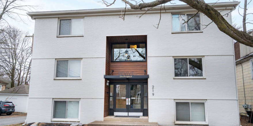 a white building with a black door and window