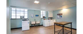 a kitchen with a table, washer and dryer in it