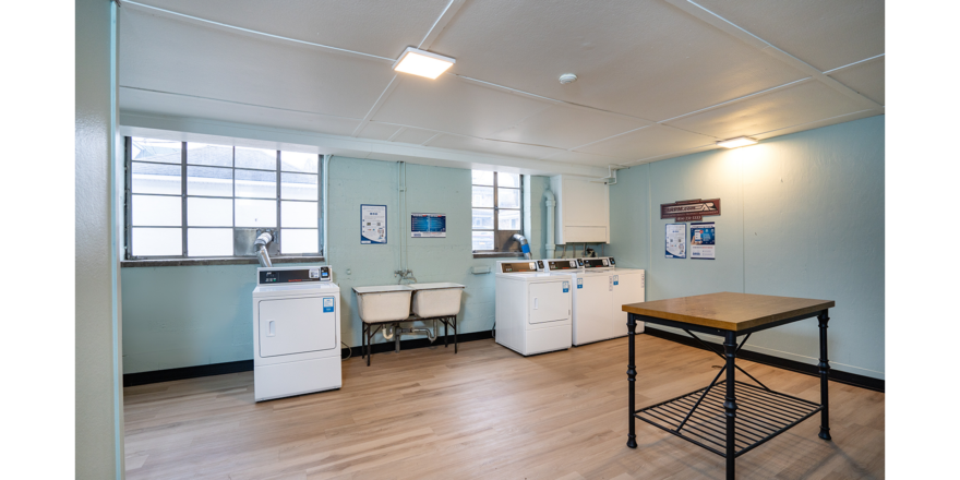 a kitchen with a table, washer and dryer in it