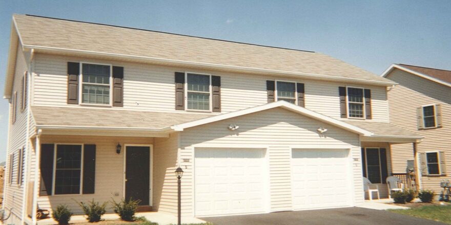 a two story house with a driveway in front of it