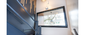 a hallway with a mirror and stairs leading up to it