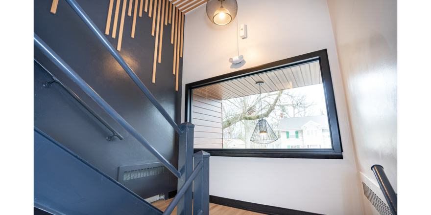 a hallway with a mirror and stairs leading up to it