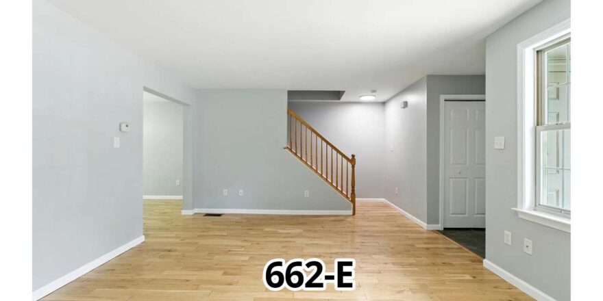 a living room with hard wood floors and white walls