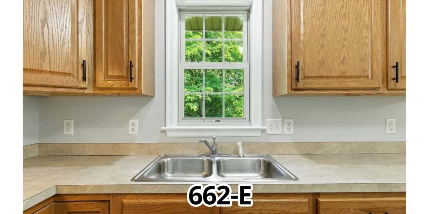 a kitchen with wooden cabinets and a white window