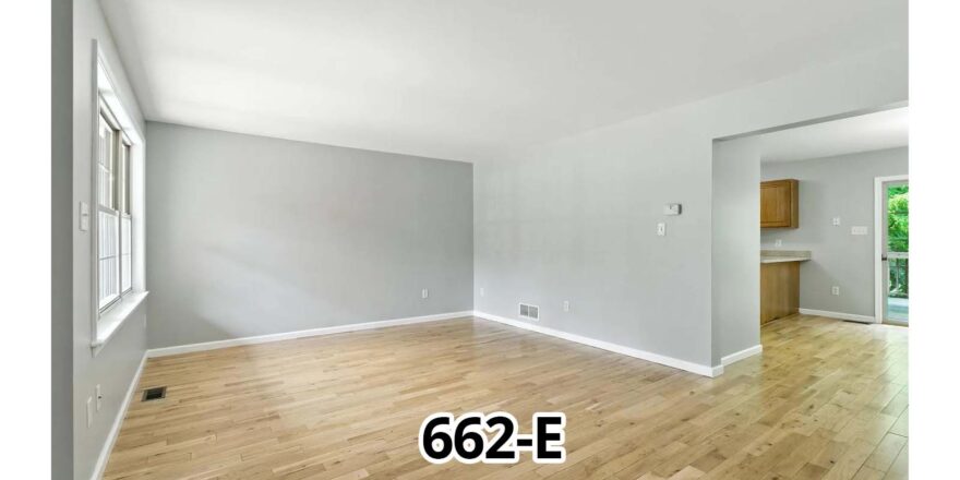 an empty room with a wood floor and a window