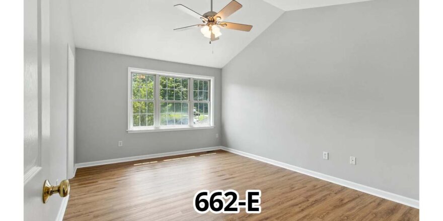 an empty room with a ceiling fan and a window