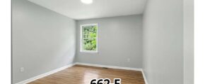 an empty room with wood floors and a window