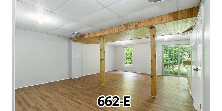 an empty room with wood floors and white walls