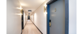 a long hallway with blue doors and white walls