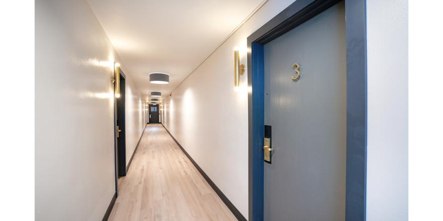 a long hallway with blue doors and white walls