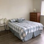 Bedroom with full-size bed, end table, and dresser