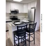 Kitchen with white cabinets, stainless steel appliances and granite-style counter tops