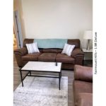 Living room with sofa, loveseat, coffee table, end table and decor