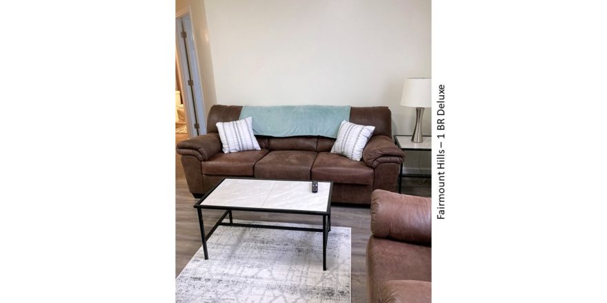 Living room with sofa, loveseat, coffee table, end table and decor