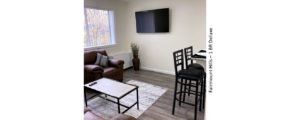 Living room with arm chair, barstools, potted plant, tv, and decor