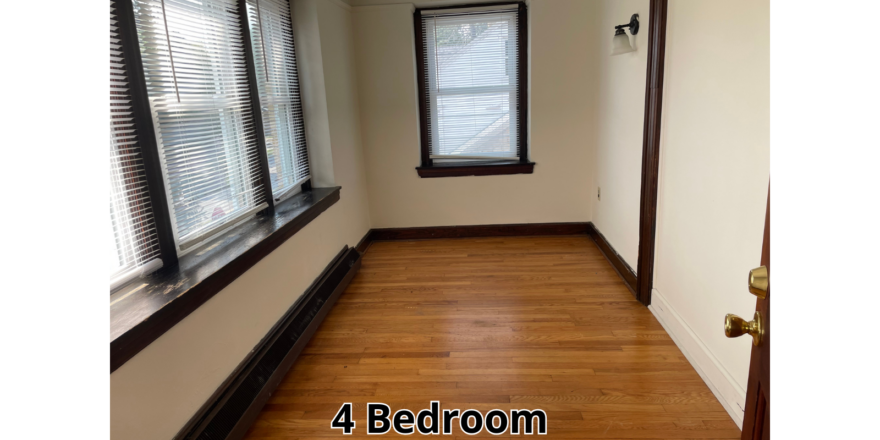 an empty room with wood floors and windows