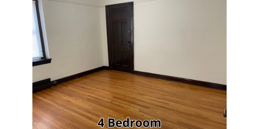 an empty room with wood floors and a door
