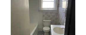 a bathroom with a sink, toilet and window