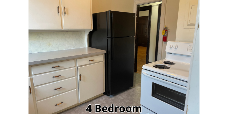 a kitchen with white cabinets and black appliances