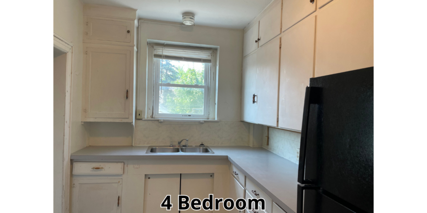 a kitchen with white cabinets and a black refrigerator