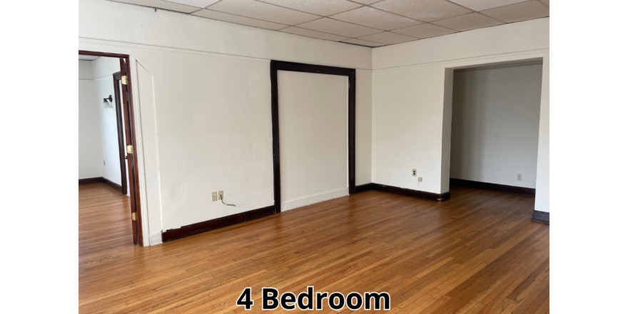 an empty room with wood floors and a ceiling fan