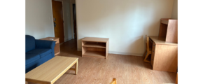 a living room with a blue couch and a wooden table