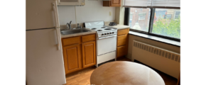 a kitchen with a table, stove and refrigerator