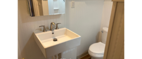 a bathroom with a sink, toilet and mirror