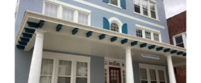 a blue and white house with columns and windows