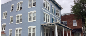 a large blue building with white trim and windows