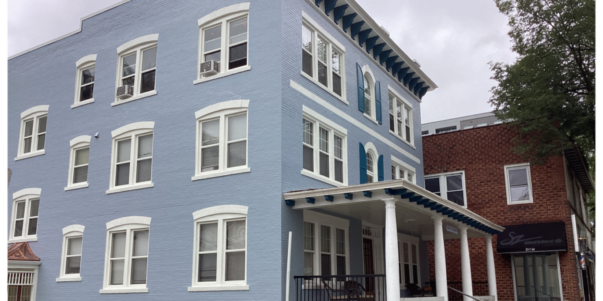 a large blue building with white trim and windows