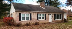 Exterior of light brick house, and black shutters