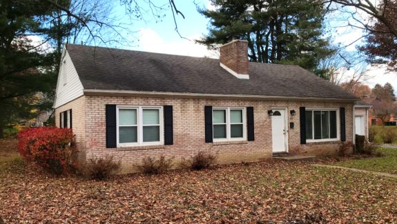 Exterior of light brick house, and black shutters