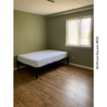 a bed sitting in a bedroom next to a window