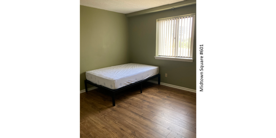 a bed sitting in a bedroom next to a window