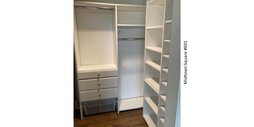 an empty closet with white shelves and drawers