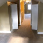 Carpeted attic flex room with two small closets