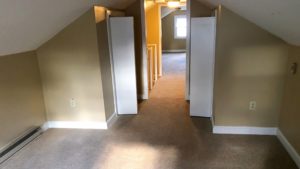 Carpeted attic flex room with two small closets