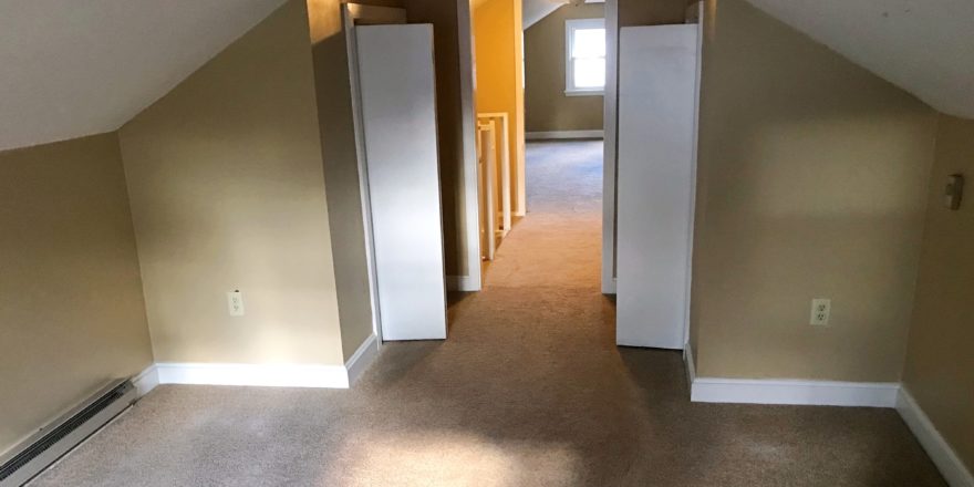 Carpeted attic flex room with two small closets